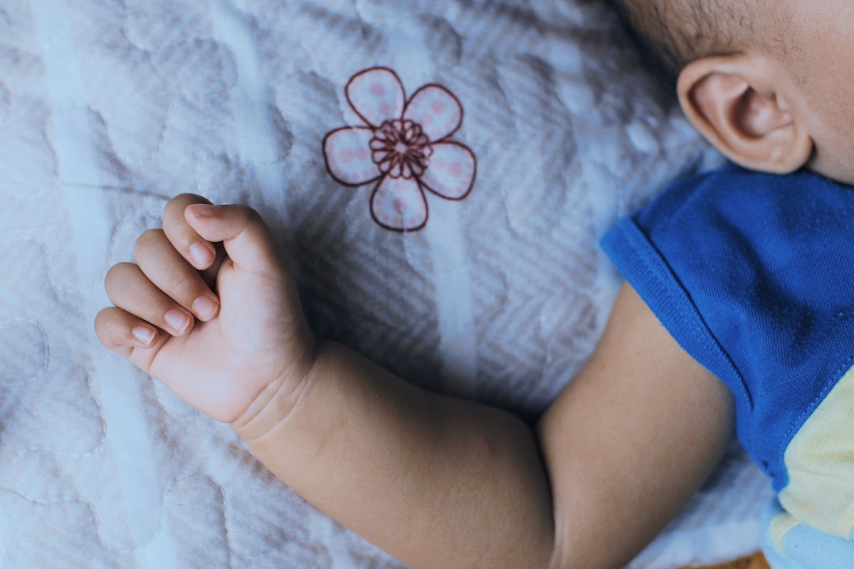 a baby laying on top of a white blanket