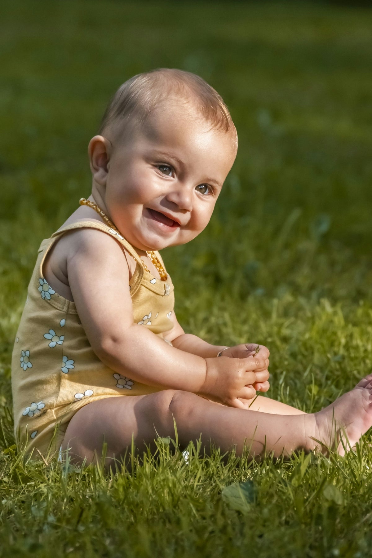 a baby girl sitting in the grass