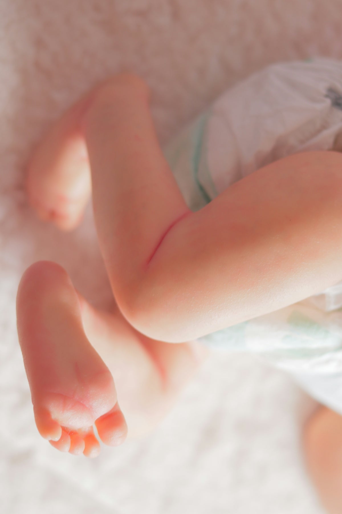 a baby laying on top of a white blanket