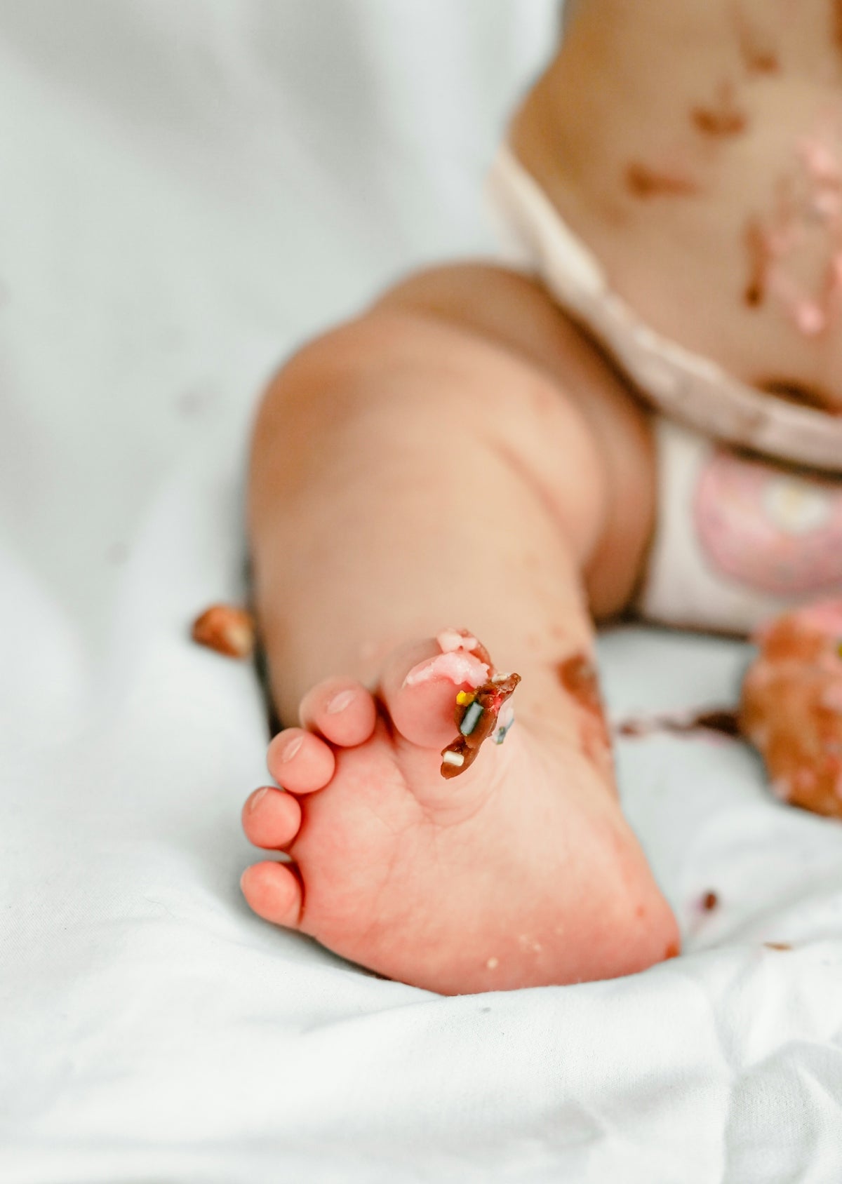 Baby's foot covered in frosting and sprinkles