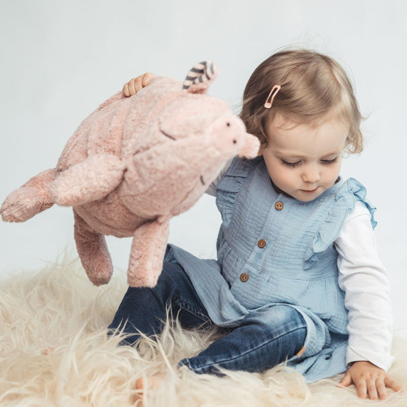 Mädchen mit Kuscheltier Schwein