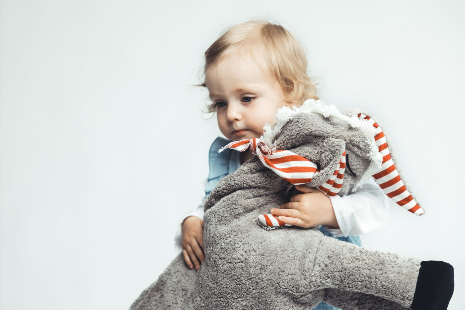 Ein Kleinkind entdeckt neugierig ein mit natürlichen Materialien gefülltes Kuscheltier.
