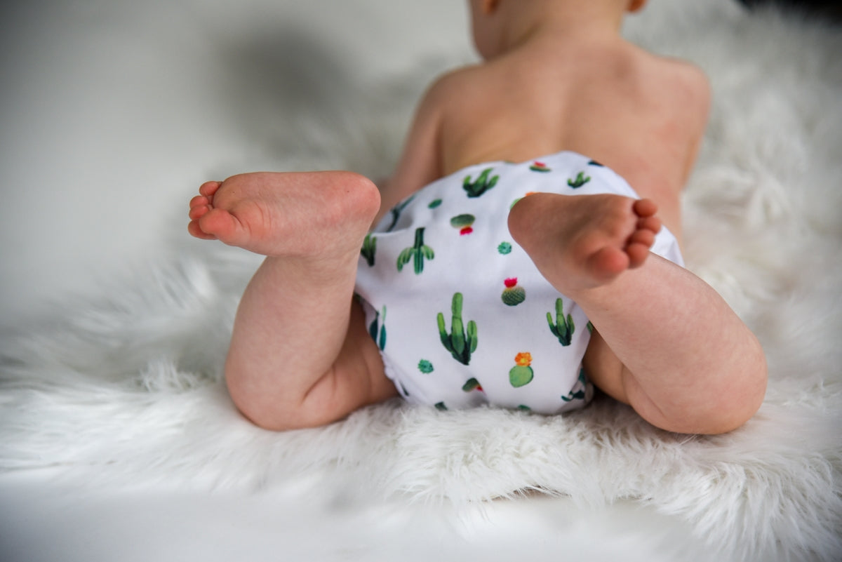 a baby wearing a diaper with a cactus print on it