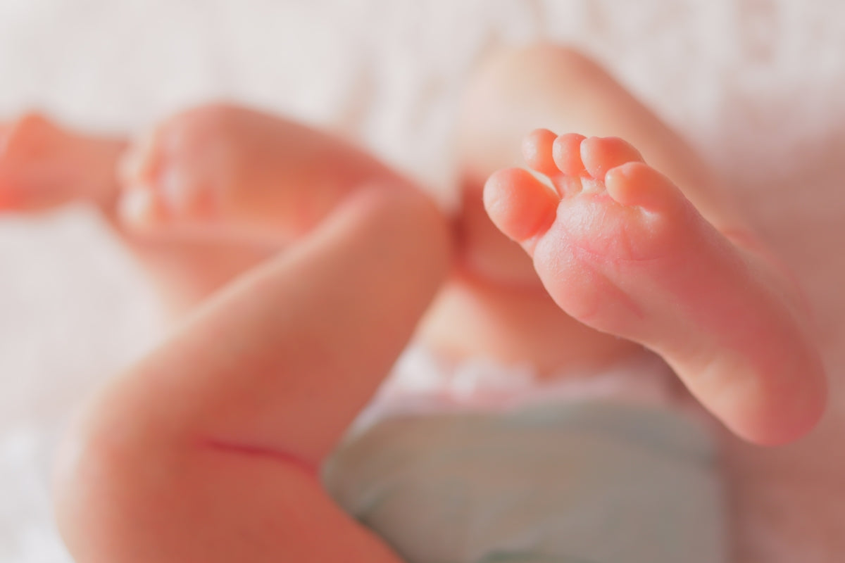 a close up of a baby's foot on a bed