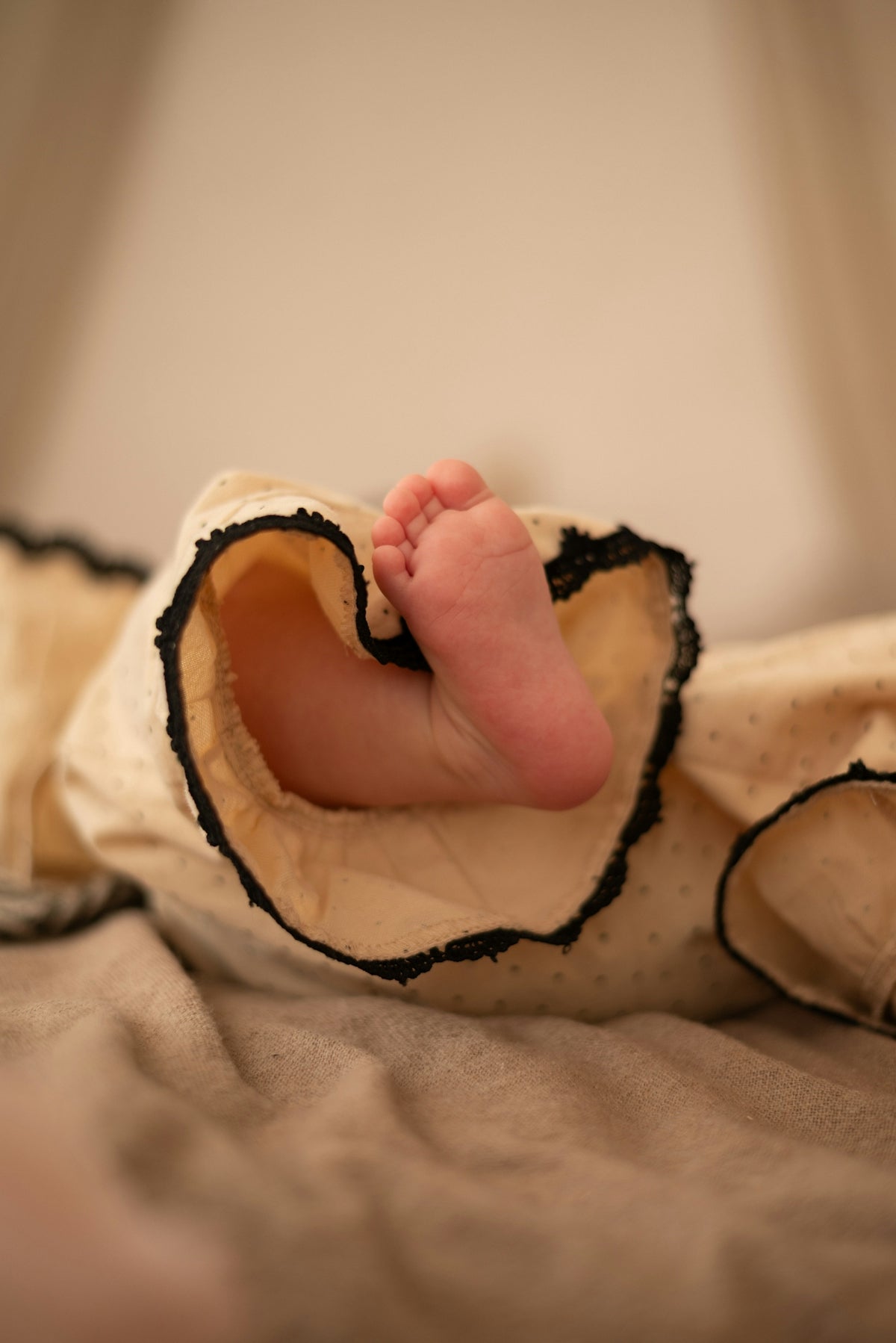 A tiny baby's foot peeks out from clothes.