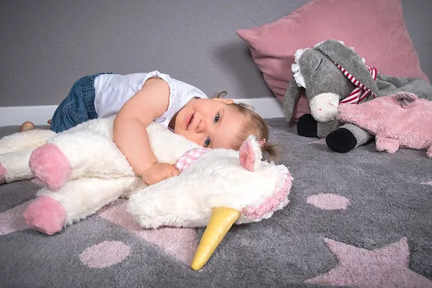 Mädchen liegt mit ihre Einhorn Kissen