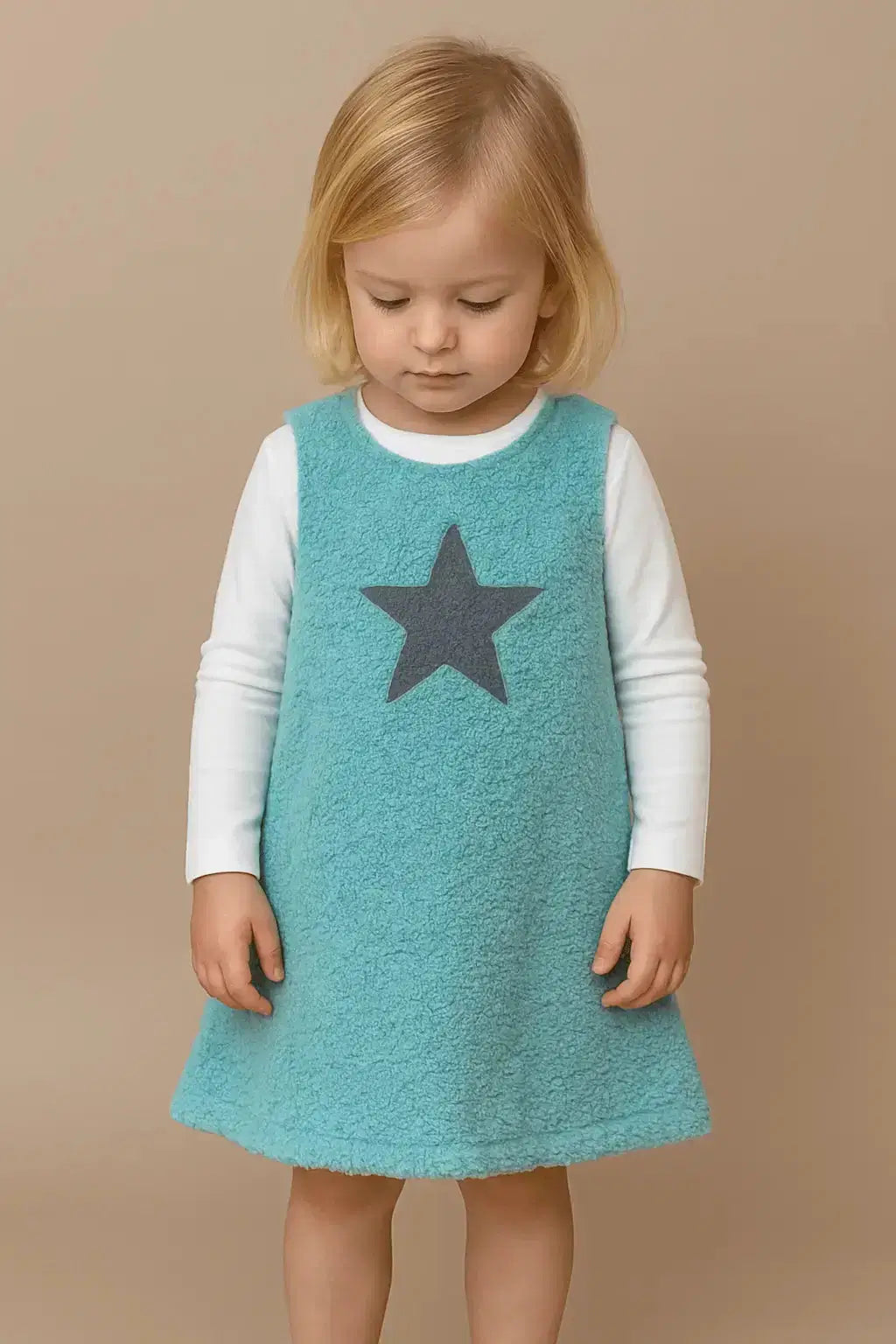 Eine Mädchen mit ein Stern Kleid aus Bio Plüsch von Pat & Patty